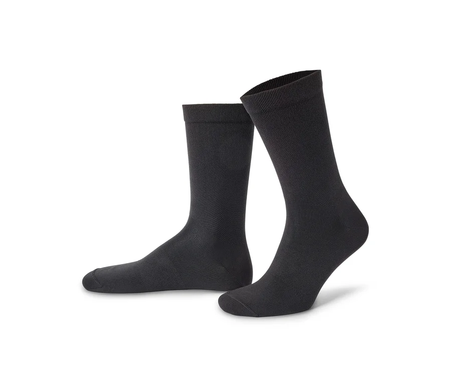 Zwei schwarze Socken stehen auf einem weißen Hintergrund.