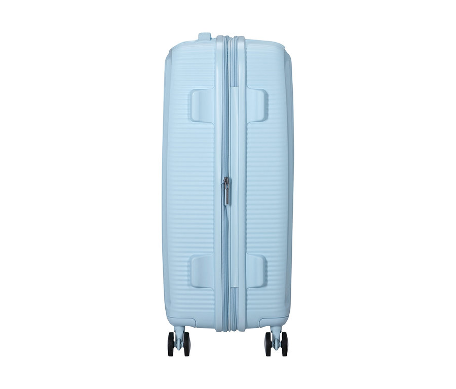 American Tourister Soundbox Spinner Hartschalen-Koffer, mittel, in Pastellblau mit gerippter Oberfläche und Reißverschluss.