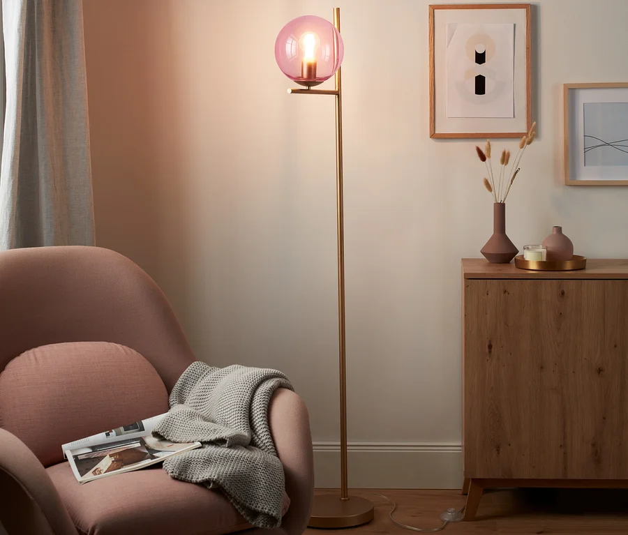 Rosa Sessel mit Decke und Stehleuchte »Glaskugel« im Wohnzimmer.
