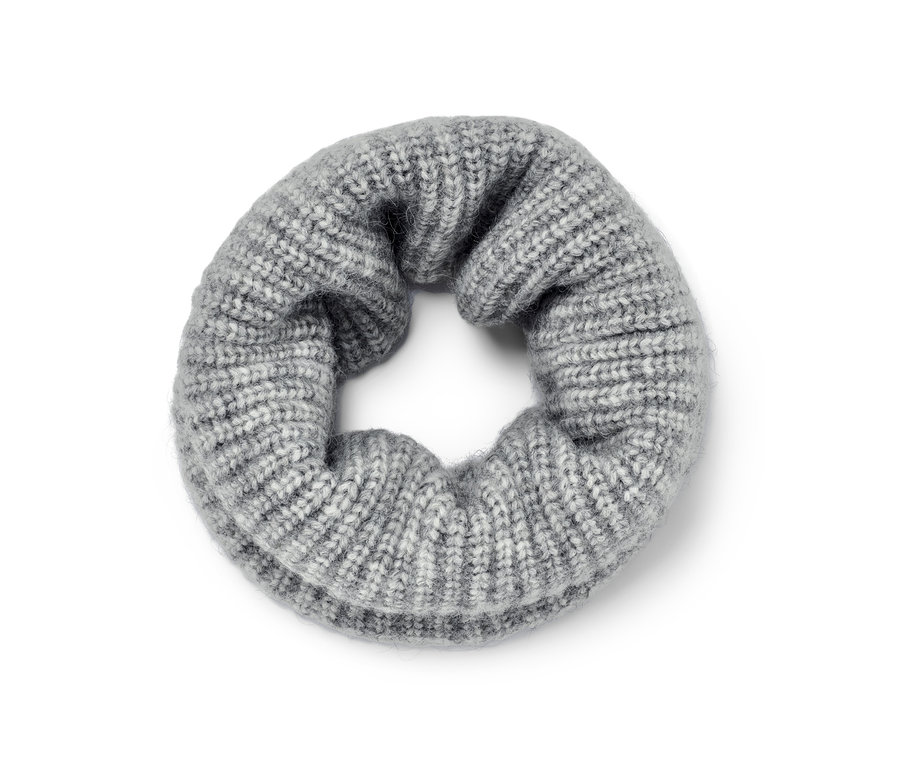 Ein grauer Strick-Loopschal liegt auf dem Boden.