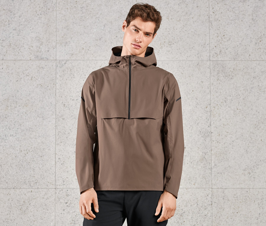Mann trägt braune Regen-Laufjacke.