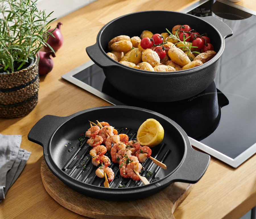 2-in-1-Gusseisen-Bräter und -Pfanne mit Garnelenspießen und Kartoffeln mit Kirschtomaten.