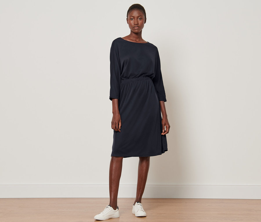 Frau steht und trägt ein Piqué-Jerseykleid.