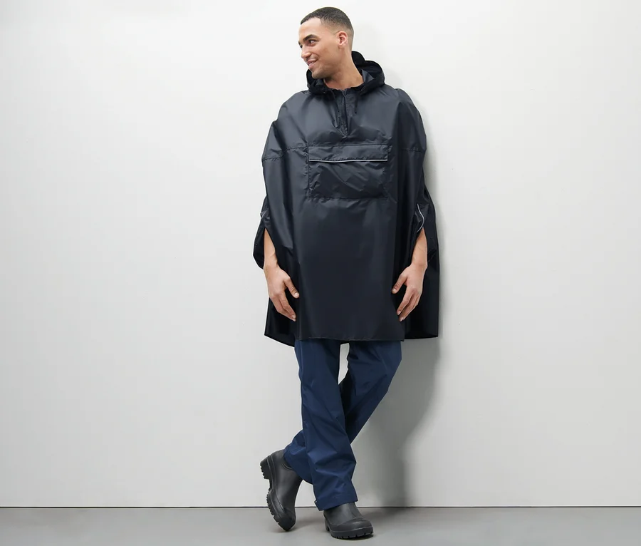 Mann posiert in blauem Unisex-Regenponcho.