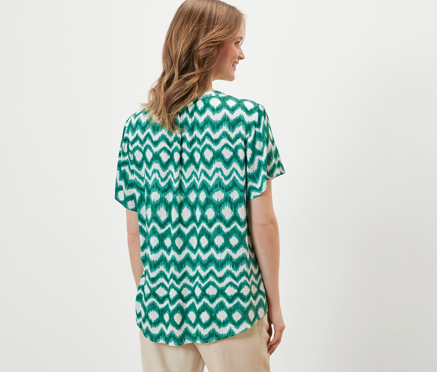 Frau trägt eine bedruckte Tunika-Bluse.