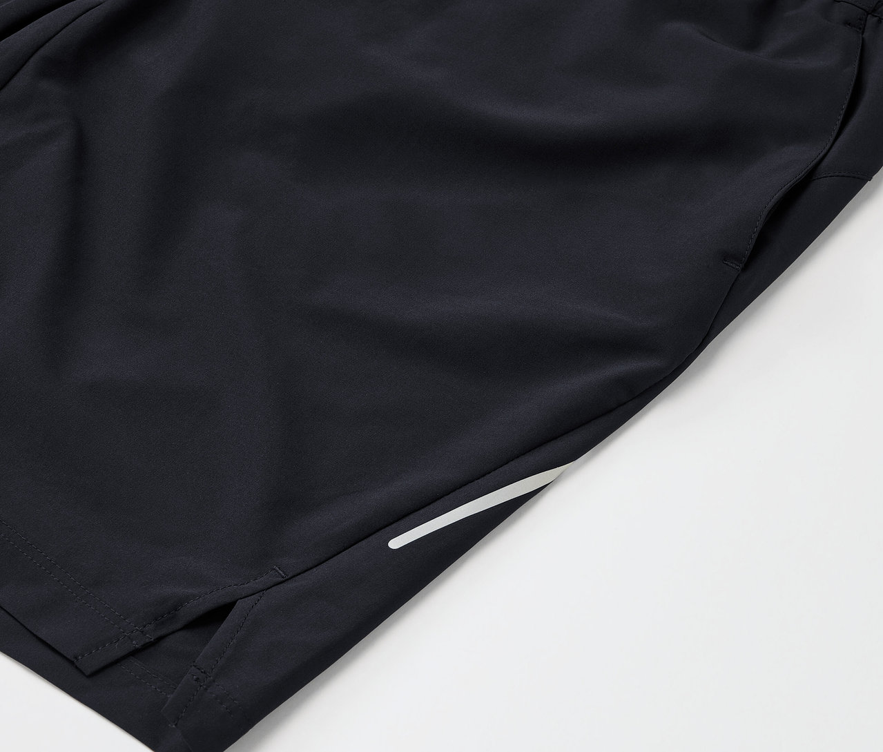 Detailaufnahme von schwarzen Sportshorts mit Tasche und Reflektorstreifen.