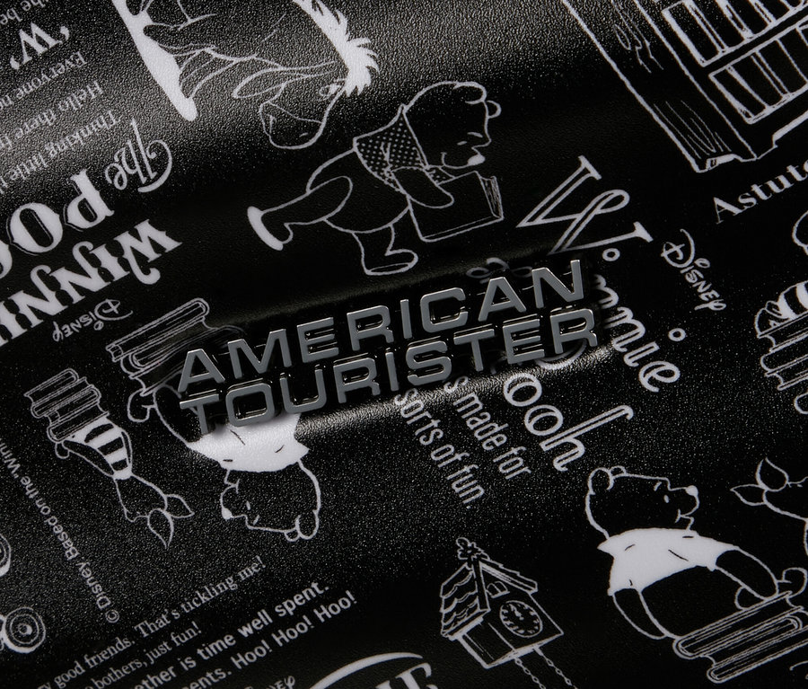 Schwarzer American Tourister Wavebreaker Koffer mit Winnie Puuh Motiv.