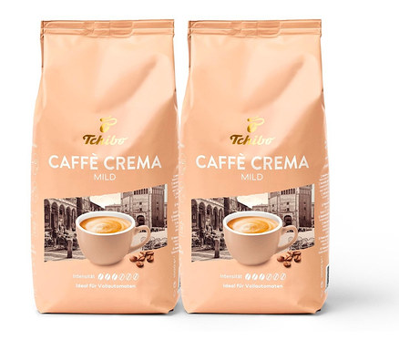 Zwei Packungen Caffè Crema Mild - 2x 1 kg Ganze Bohne von Tchibo. Auf der Packung ist eine Tasse Kaffee und ein Gebäude abgebildet.