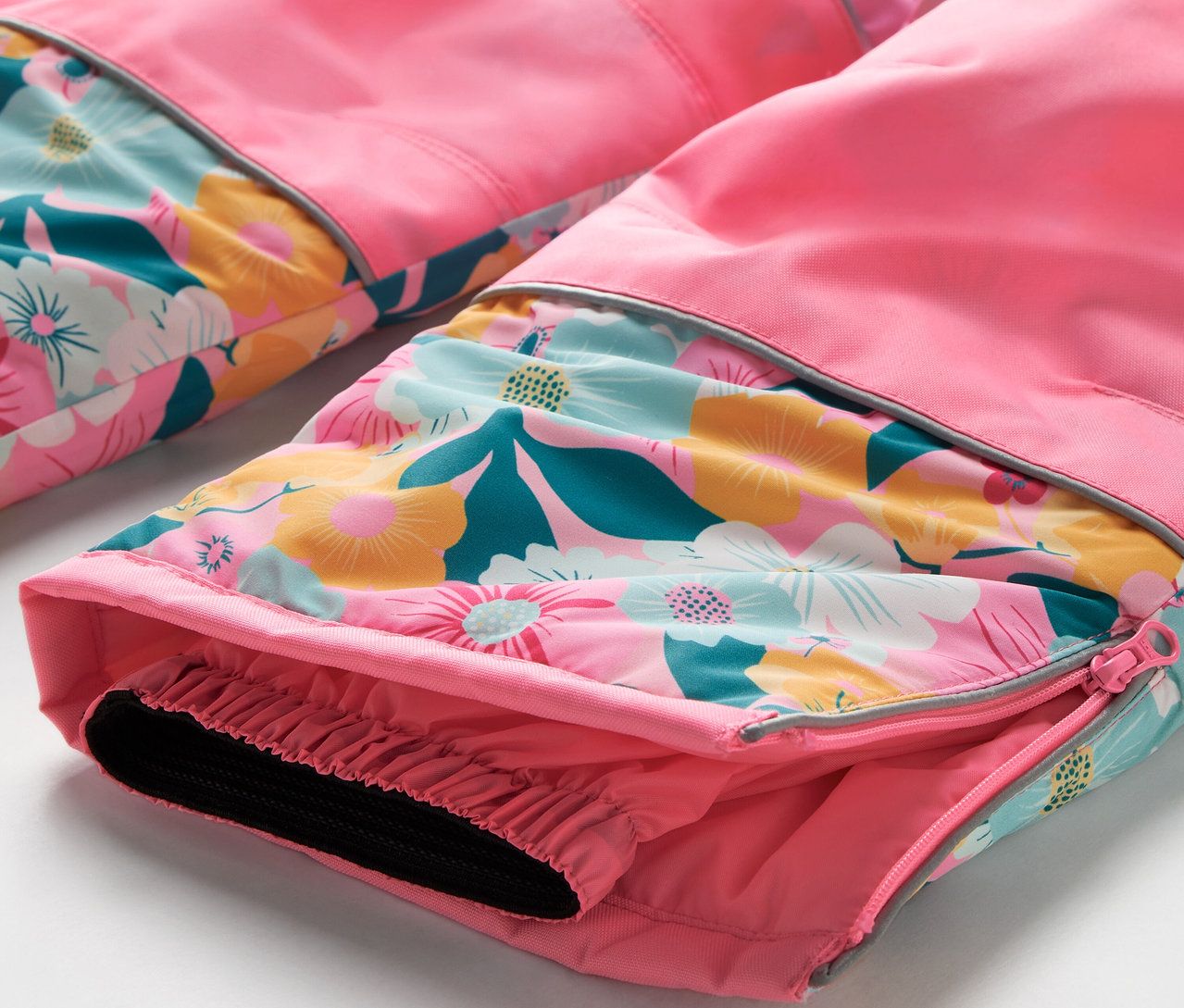 Detail einer rosa Hose mit Blumenmuster und elastischem Saum.