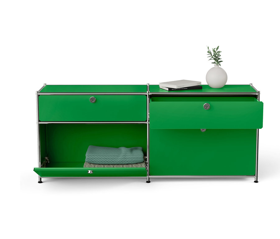 Grüner Schrank mit offenen Türen, Buch und Vase oben drauf.
