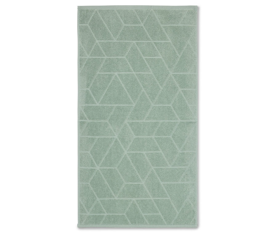 Ein hellgrünes Handtuch mit geometrischem Muster liegt flach auf einer weißen Oberfläche.