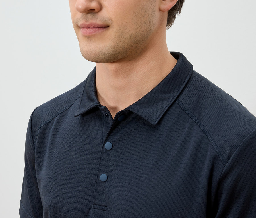 Nahaufnahme eines Mannes mit einem dunkelblauen Poloshirt.