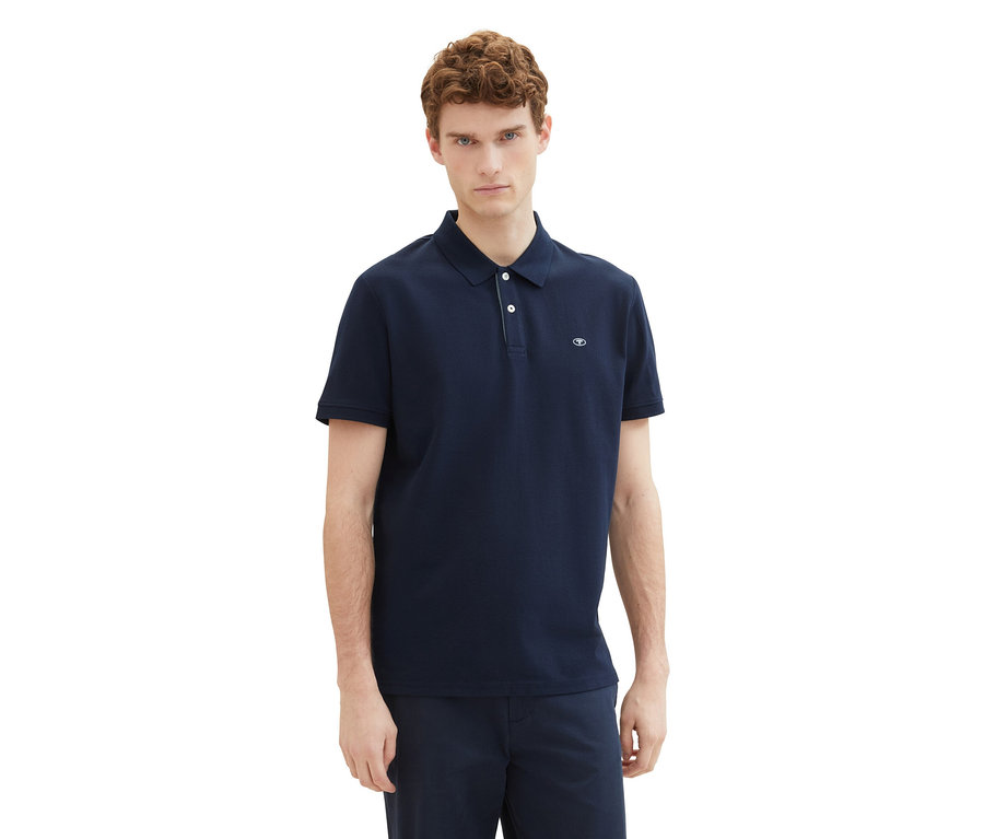 Mann trägt ein Tom Tailor Piqué Poloshirt in Sky Captain Blue.