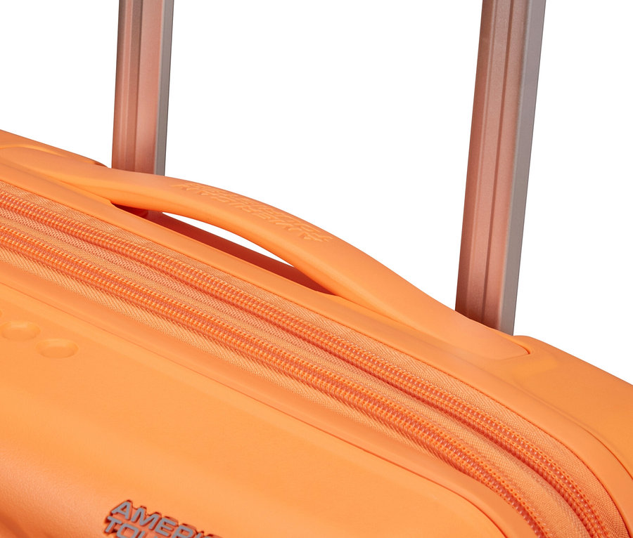 Detailansicht eines orangefarbenen Koffers mit silberfarbenem Griff.