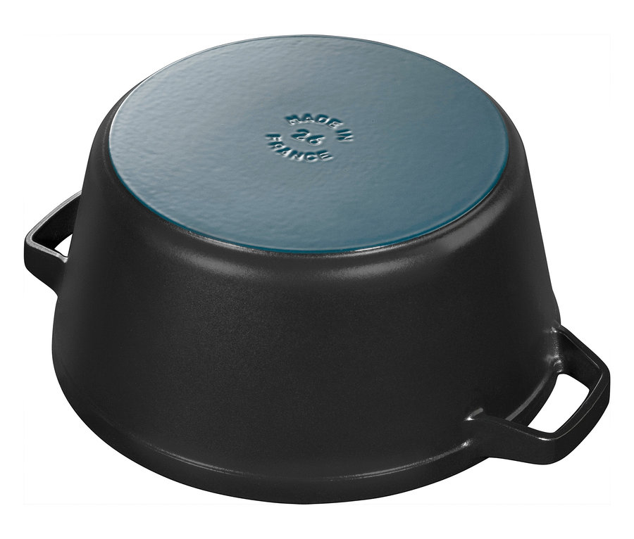 Nahaufnahme eines umgedrehten, schwarzen STAUB Kochtopfs aus dem 3-teiligen »La Cocotte« Kochtopf-Set, der auf einer weißen Oberfläche steht.
