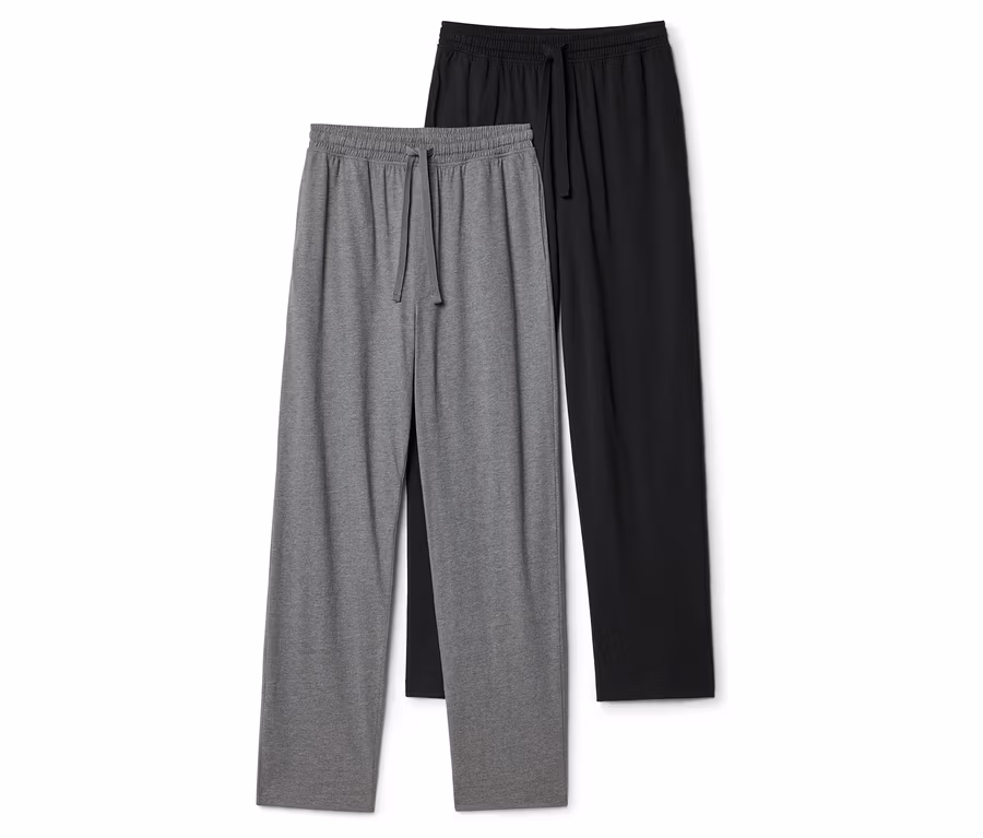 Zwei Jogginghosen, eine graue und eine schwarze, liegen flach. Beide haben einen elastischen Bund mit Kordelzug.