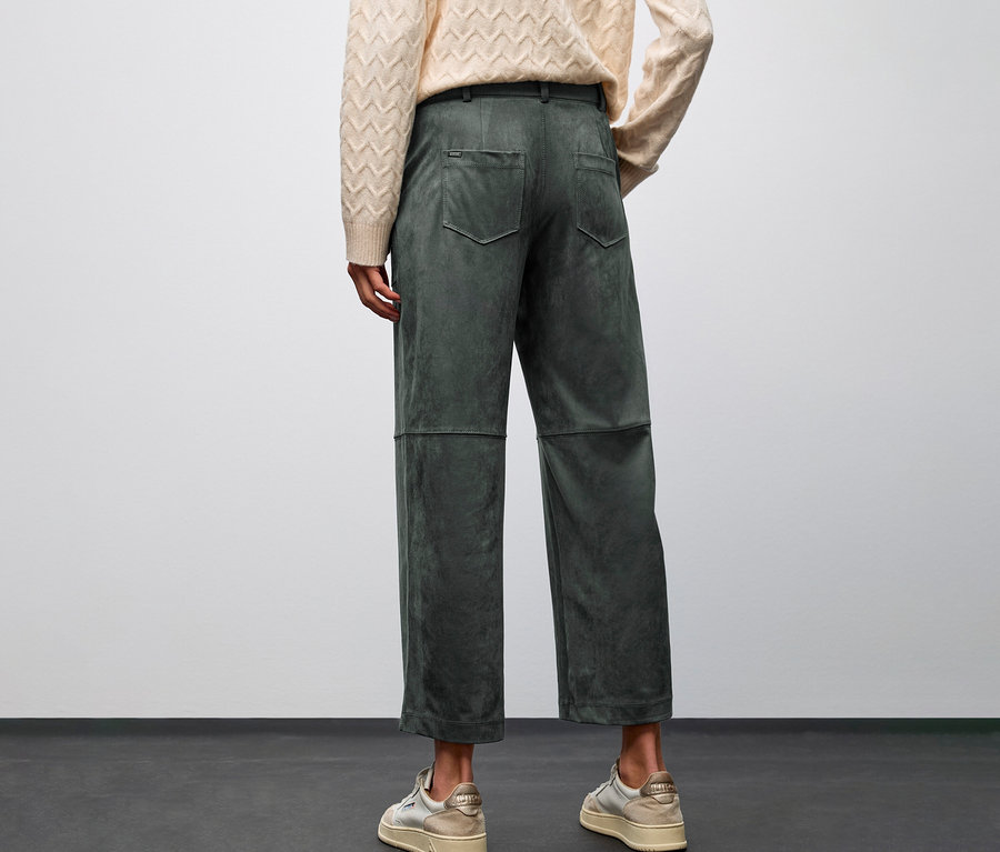 Person von hinten, trägt beige Pullover und grüne Street One Velourshose Straight Leg.