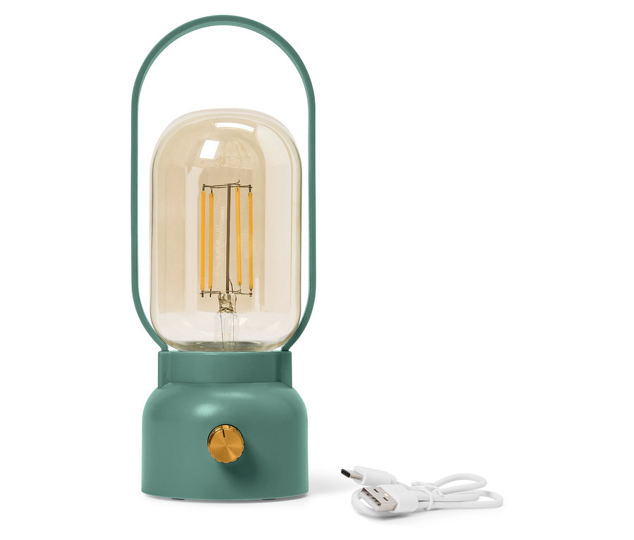 Eine grüne Lampe mit einem gelben Glaskolben steht neben einem weißen USB-Kabel.