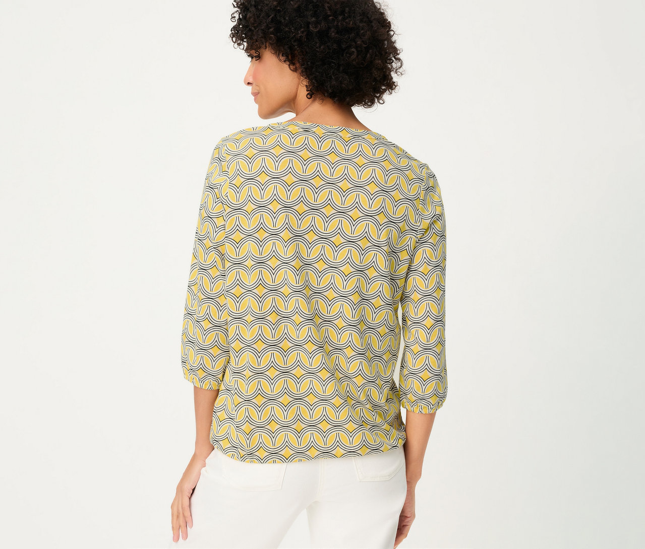 Frau von hinten mit Olsen 3/4-Blusenshirt mit gelbem Muster und weißen Hosen.