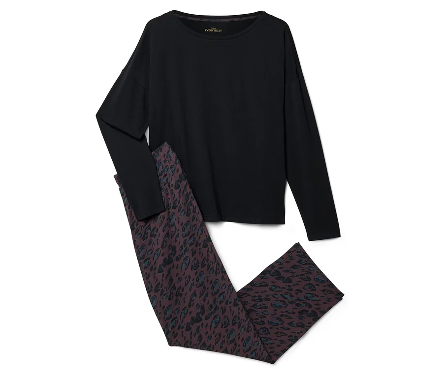Ein schwarzes Langarmshirt und eine dunkelbraune Hose mit blau-schwarzem Leopardenmuster, flach auf weißem Hintergrund liegend.