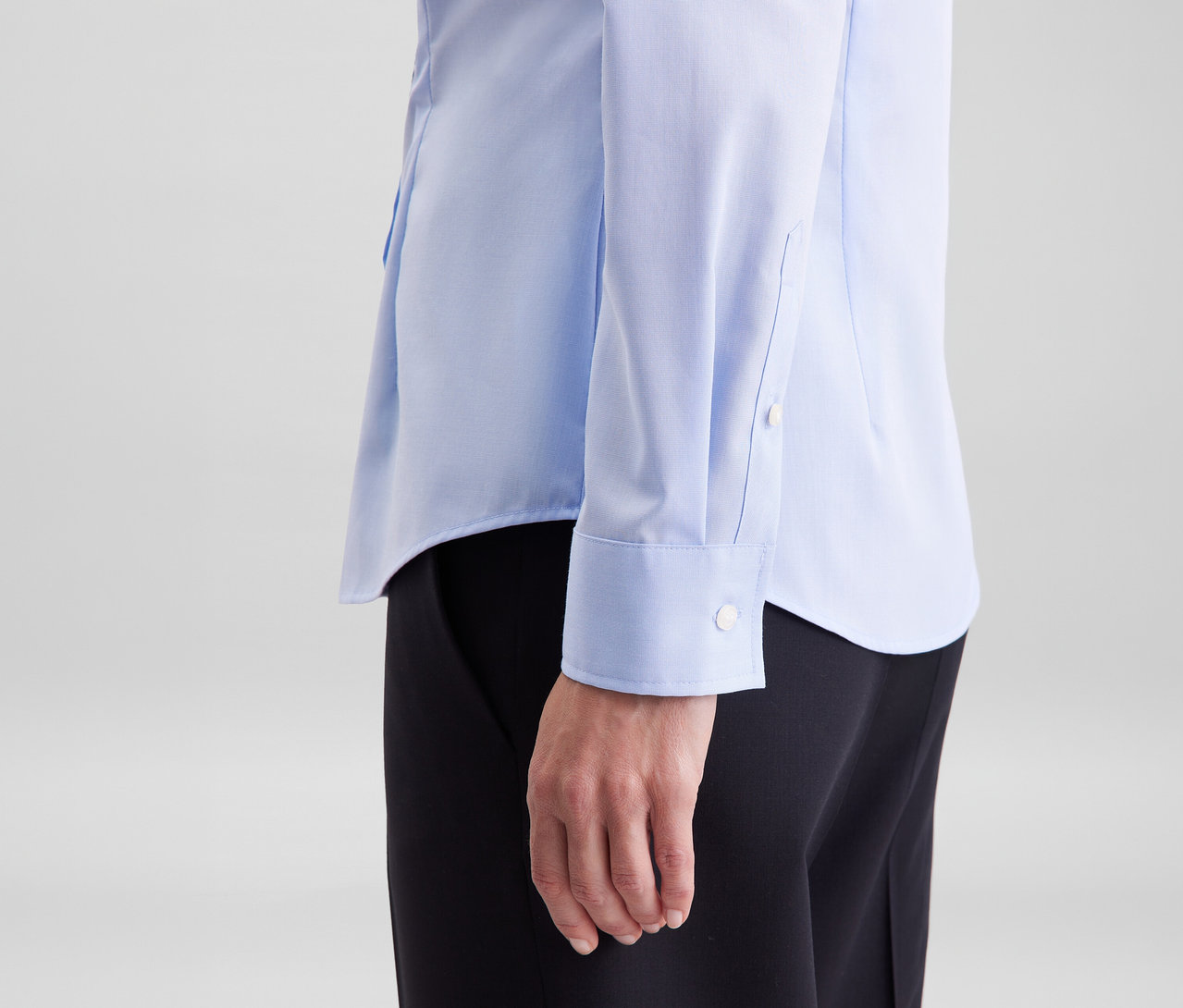 Person trägt eine hellblaue Seidensticker Bluse Slim Fit non iron und schwarze Hose.