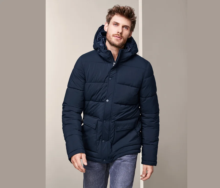 Mann trägt eine Thermo-Steppjacke und Jeans.