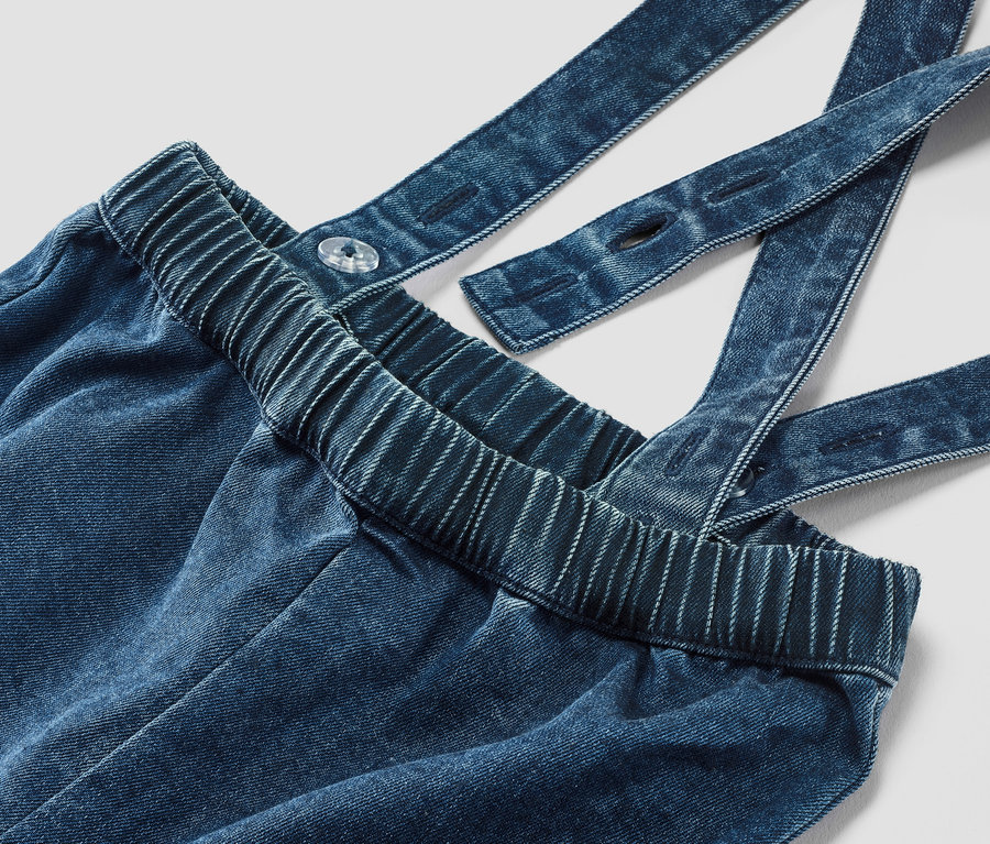 Detailaufnahme einer Baby-Twillhose mit Hosenträgern.