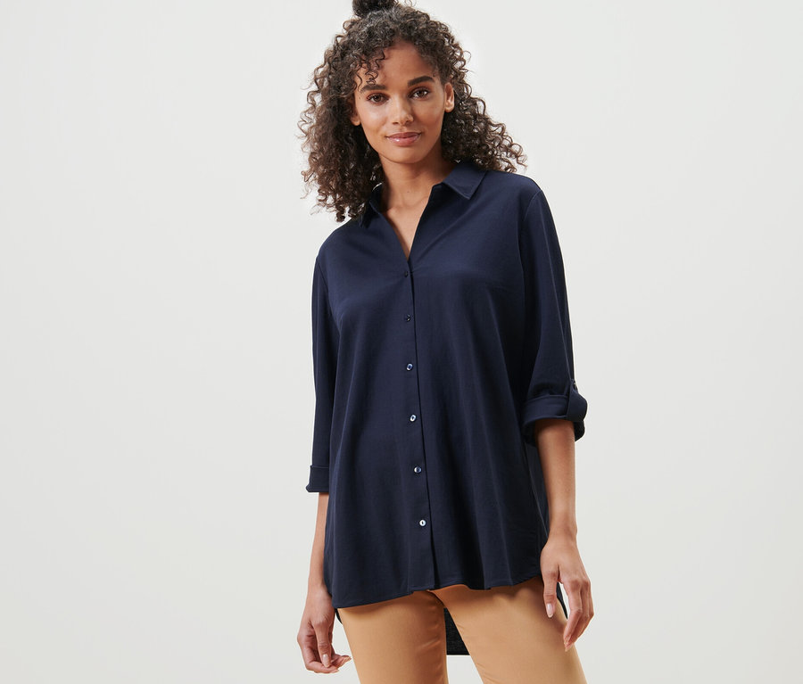 Frau posiert in dunkelblauer Piqué-Jerseybluse.