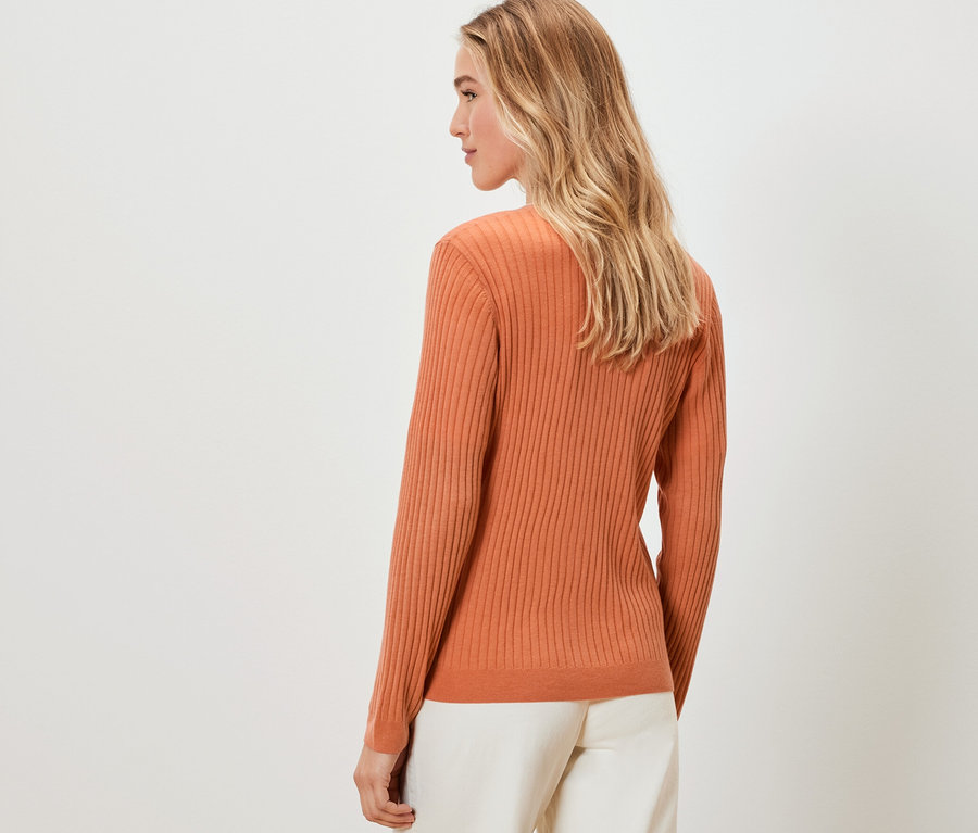 Blonde Frau in orangefarbenem Cardigan mit Seide von hinten.