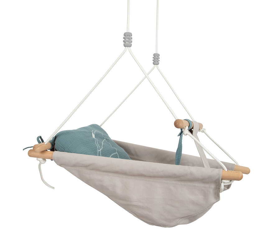 Eine hängende small foot Babyschaukel »Seaside« mit einem beigen Stoffteil und blauem Kissen.