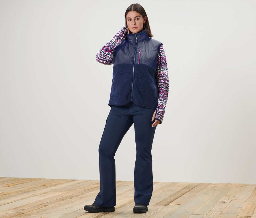 Frau posiert in Teddy-Weste, Fleecepullover und Thermo-Jazzpants.