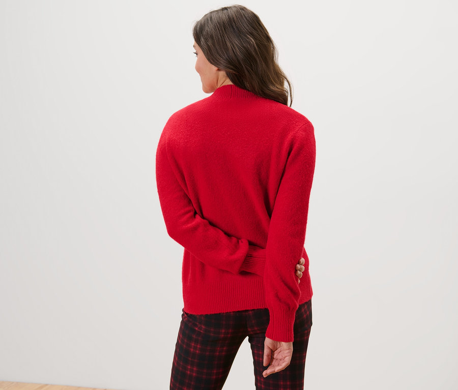 Rückansicht einer Frau in Strickjacke.