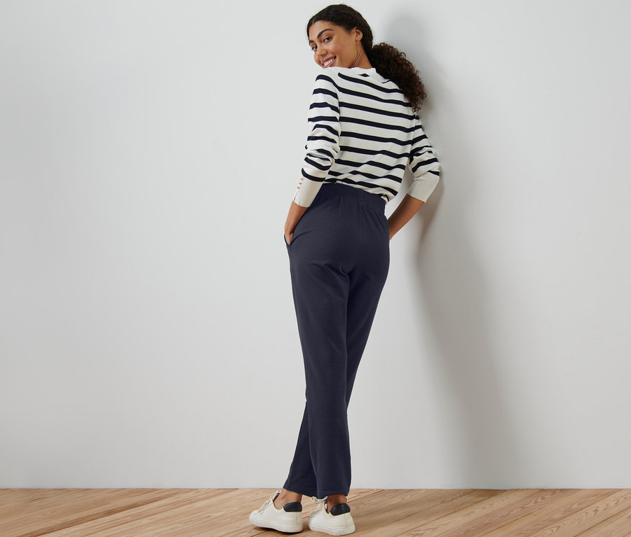 Frau posiert in marineblauen Joggpants.