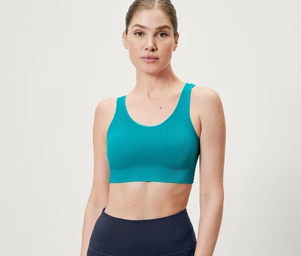 Frau trägt ein türkises Seamless-Sport-Bustier.