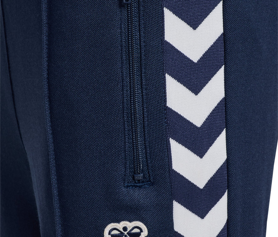 Detailansicht einer marineblauen HUMMEL HMLJR Archive Regular Poly Pants mit Reißverschluss und weißem Logo.
