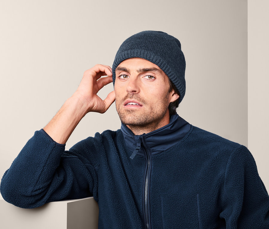 Mann trägt eine Thermo-Strickmütze und eine Fleecejacke.