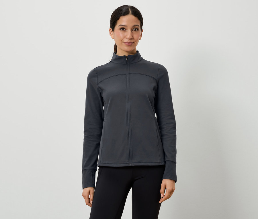 Frau trägt eine dunkelgraue Sportjacke und schwarze Leggings.