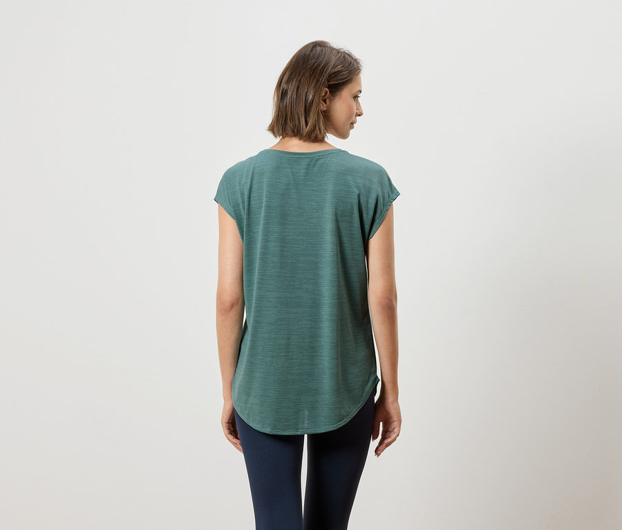 Rückansicht einer Frau mit kurzem braunem Haar, die ein grünes T-Shirt und marineblaue Leggings trägt.