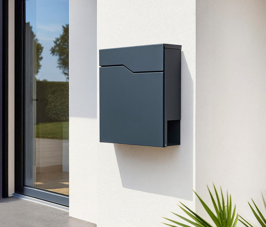 Ein dunkelblauer Briefkasten hängt an einer weißen Wand neben einer Glastür.