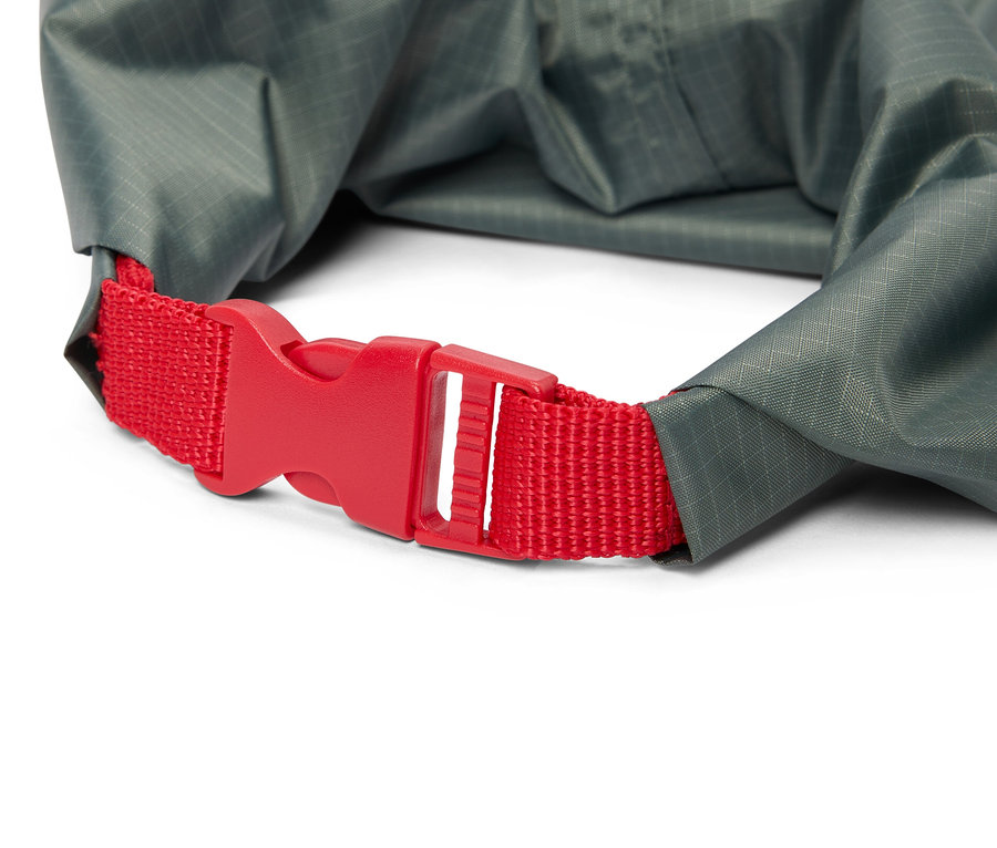 Nahaufnahme eines grauen Packsacks mit einem roten Verschluss.