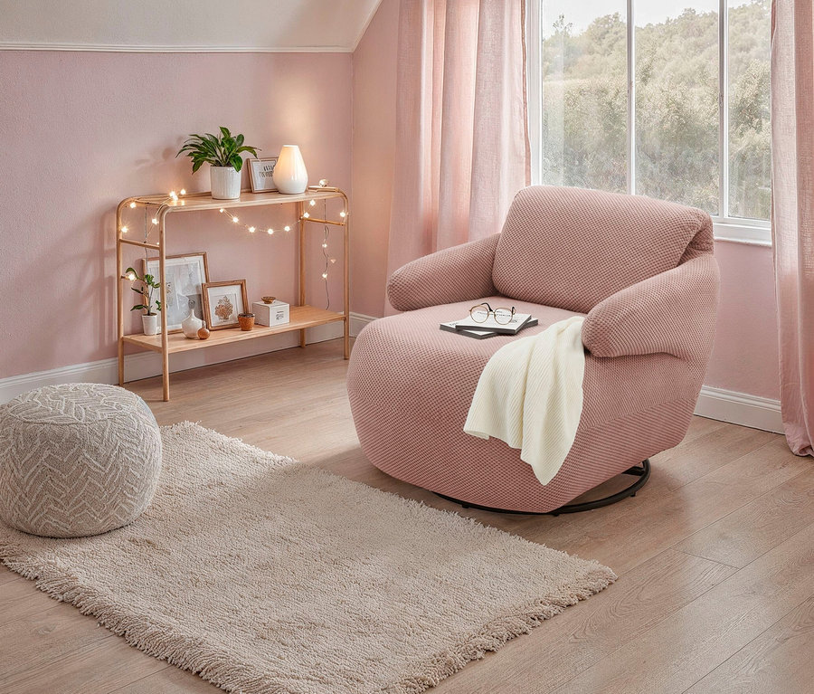 Rosa Domo Drehsessel »Valencia« mit Drehfunktion steht auf einem Teppich. Eine Brille liegt auf einem Buch auf dem Sessel.