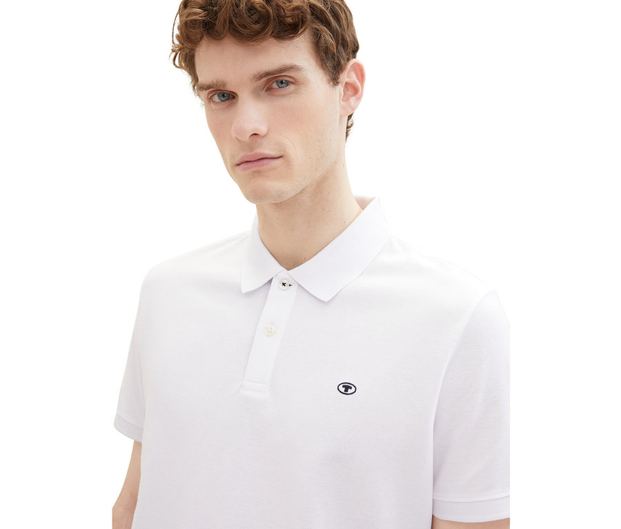 Mann trägt ein weißes Tom Tailor Piqué Poloshirt.