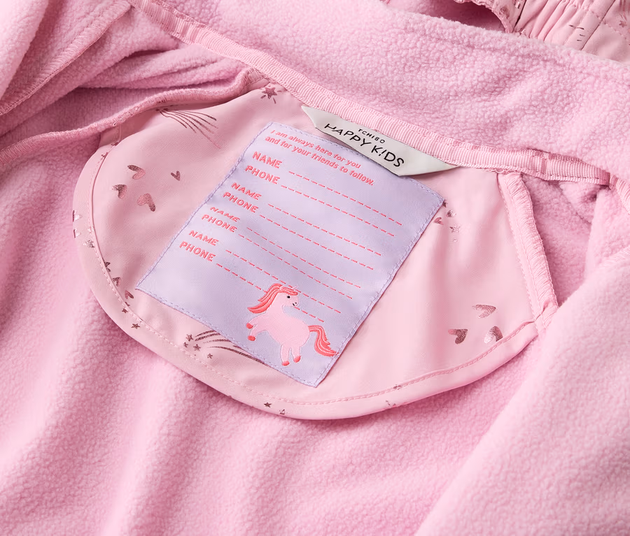 Innenansicht einer rosa Jacke mit Fleece-Futter und einem Etikett mit Einhornmotiv für Namens- und Telefonnummerangaben.