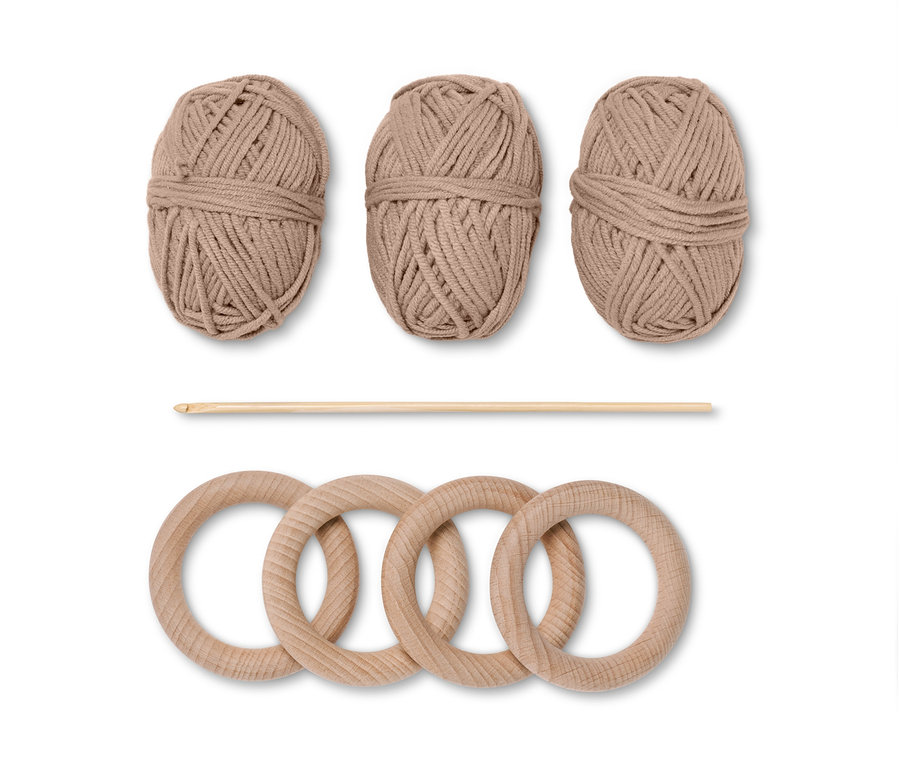DIY-Häkelset »Serviettenringe«: Drei braune Garnknäuel, eine Häkelnadel und vier Holzringe.