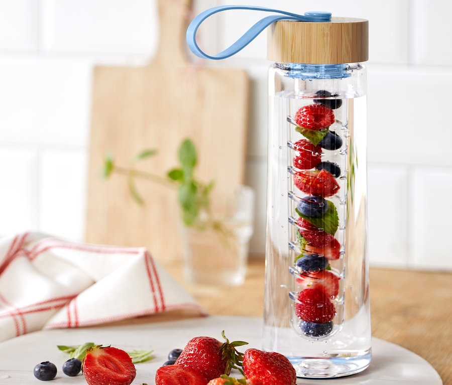 Eine Trinkflasche mit Aromaeinsatz ist mit Erdbeeren, Blaubeeren und Minze gefüllt.