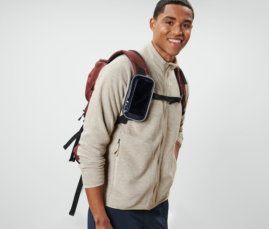 Lächelnder Mann mit Rucksack und Multifunktionstasche mit Sichtfenster.