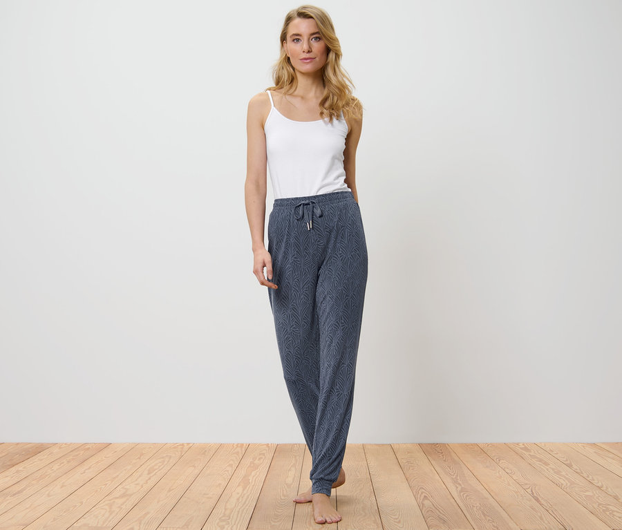 Frau trägt eine Pyjamahose und ein weißes Top.