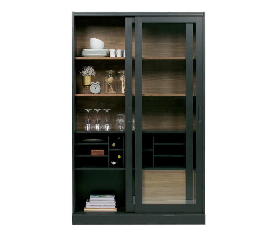 Schwarze Woood Vitrine »James« aus Kiefernholz mit Glasschiebetüren, im Inneren Regale mit Geschirr und Dekorationen.