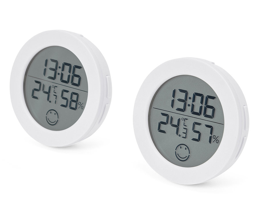 Zwei weiße digitale Thermometer, die die Uhrzeit 13:06, eine Temperatur von 24,5 Grad Celsius und eine Luftfeuchtigkeit von 58 % und 57 % anzeigen.