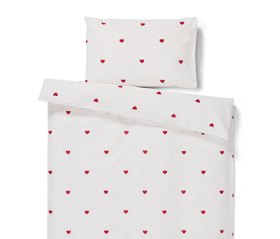 Weiße Bettwäsche mit roten Herzen.